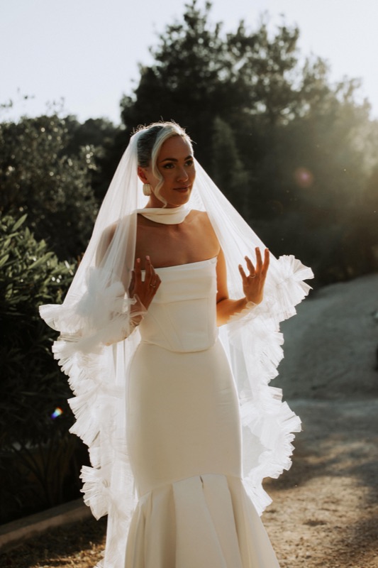Bride in sunlight with long veil