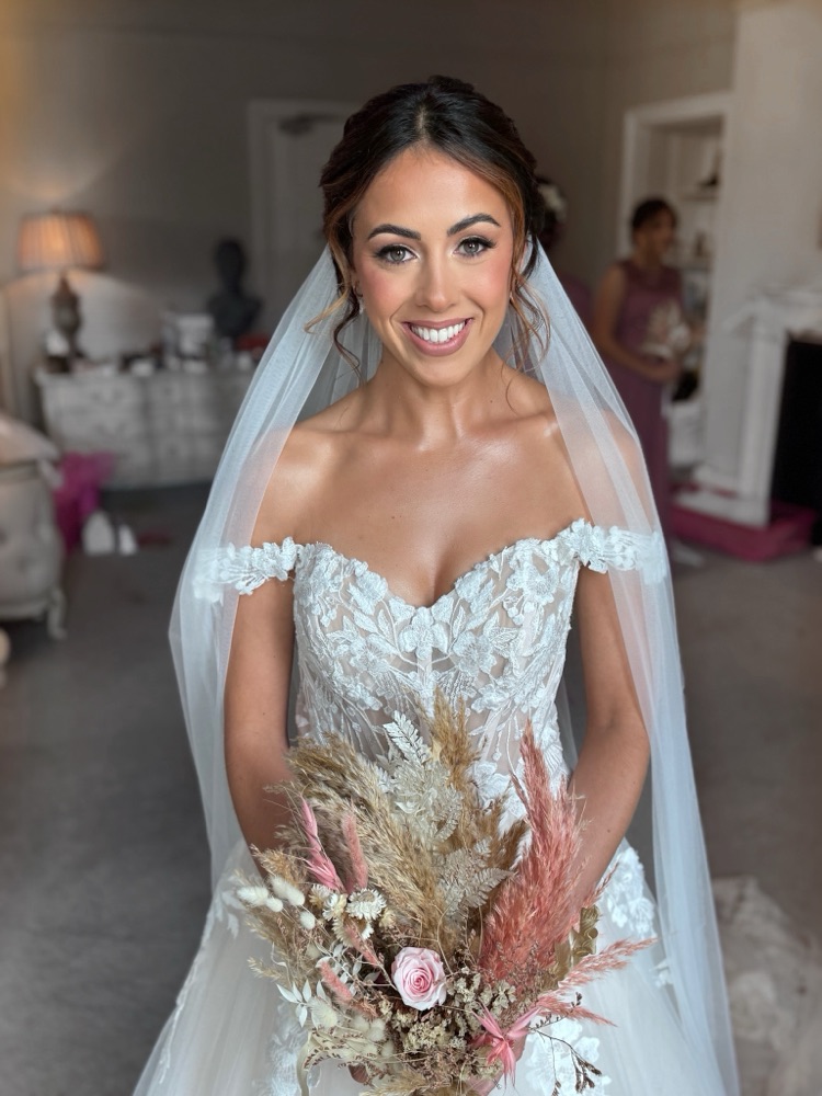 Bride with glowing skin and off-shoulder lace dress