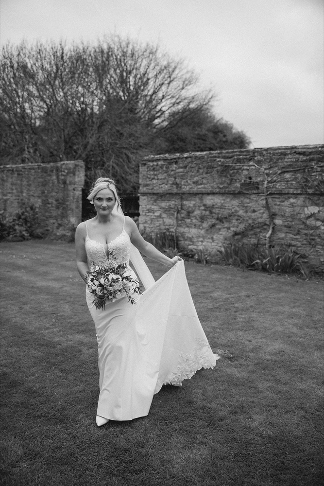 Black and white photo of bride in a walled garden